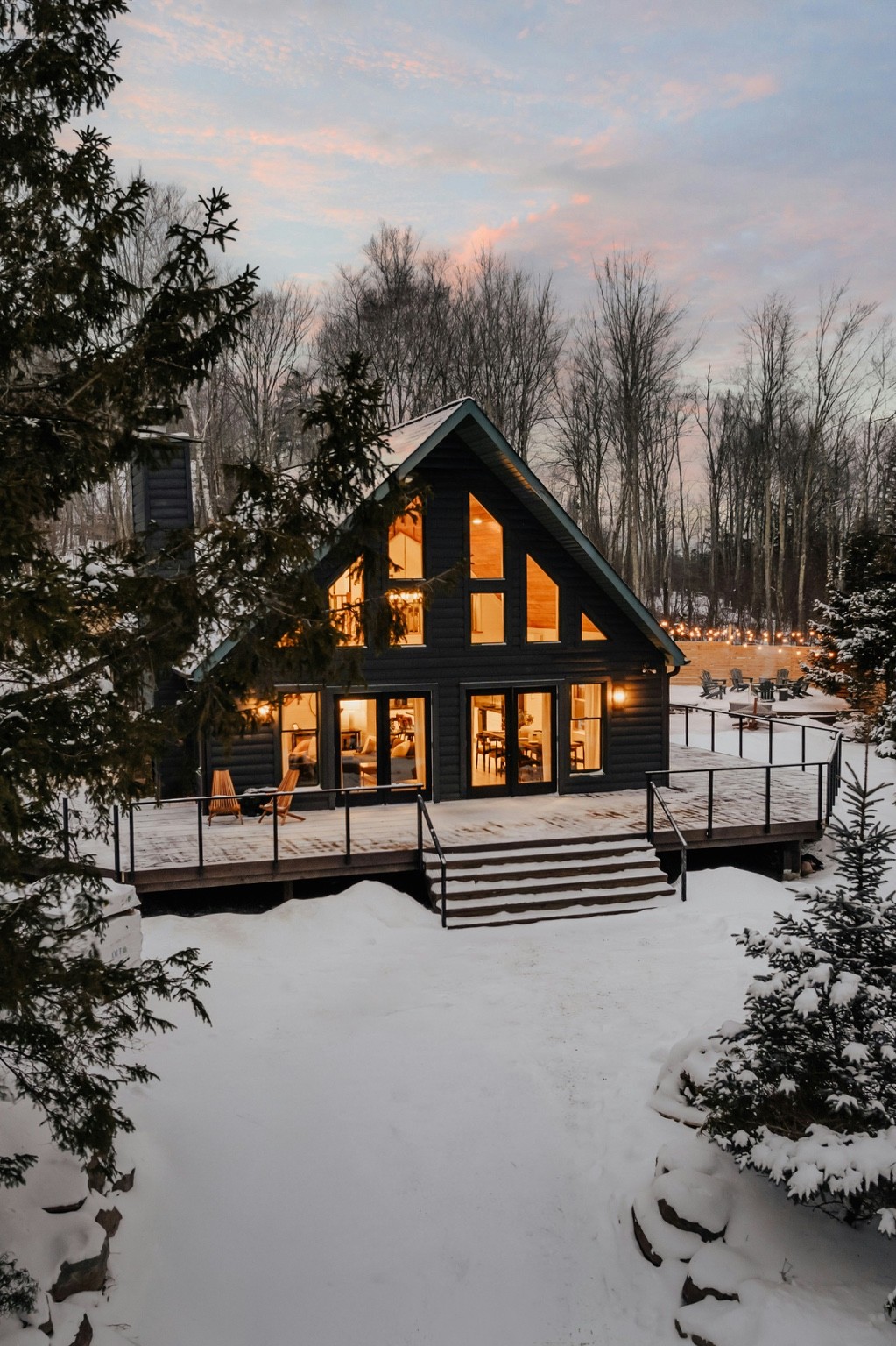 Snow-covered New England-style cabin with warmly illuminated windows